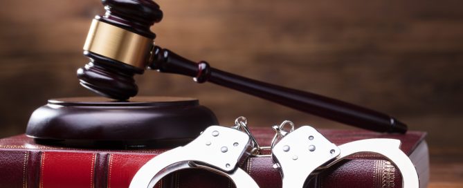 Gavel and handcuffs representing legal consequences of non-compliance
