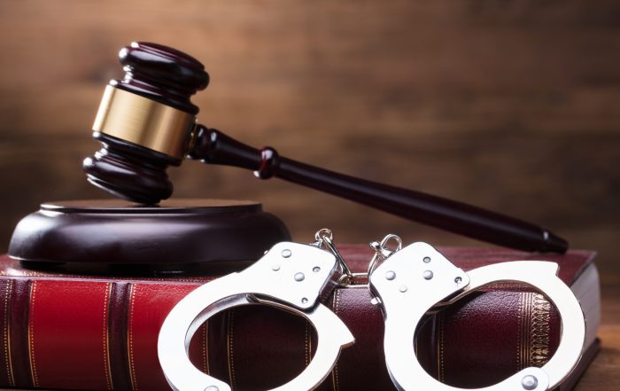 Gavel and handcuffs representing legal consequences of non-compliance
